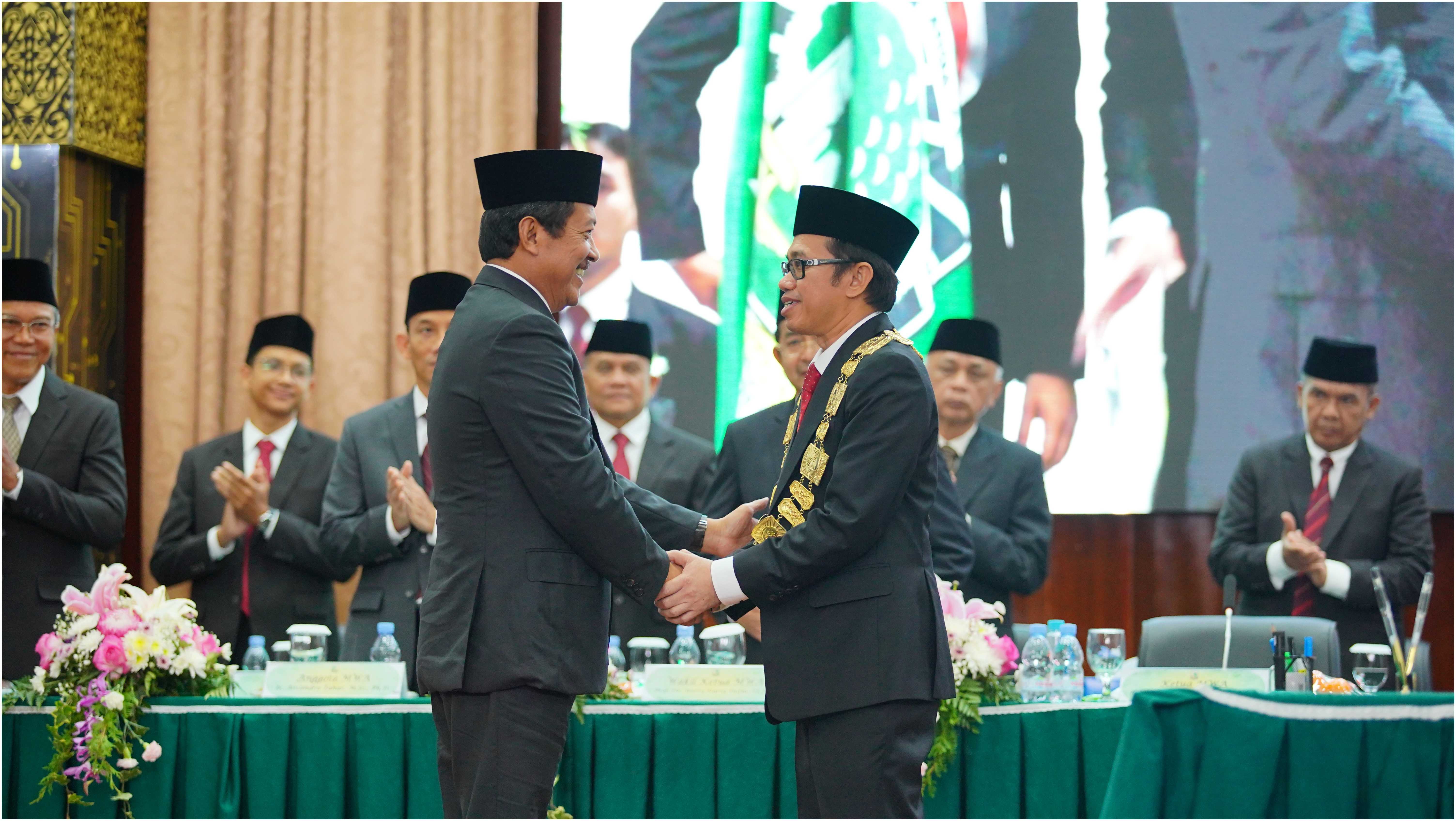 Pengalungan Tanda Jabatan Rektor oleh Ketua MWA (kiri) kepada Rektor Terpilih Dr. Efa Yonnedi (kanan)